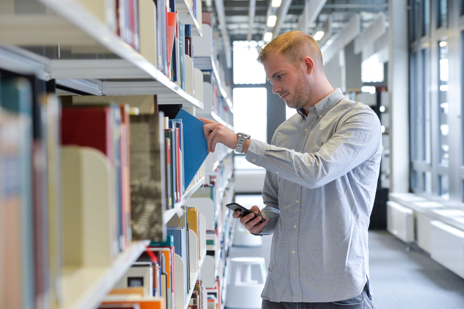 Studierender an Bücherregal