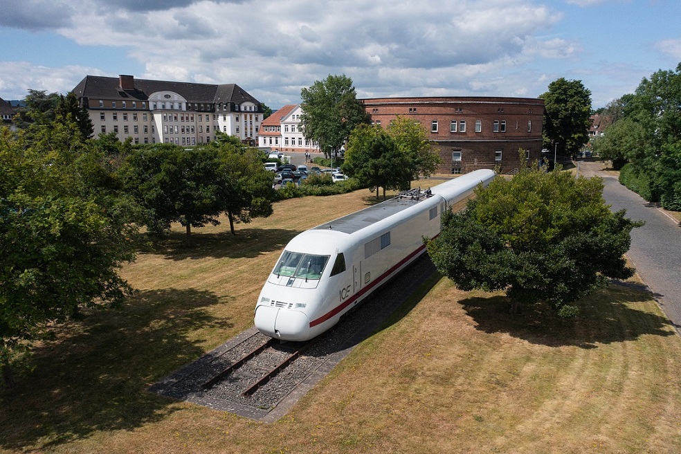 Zugwagon steht auf Schienen auf einer Wiese