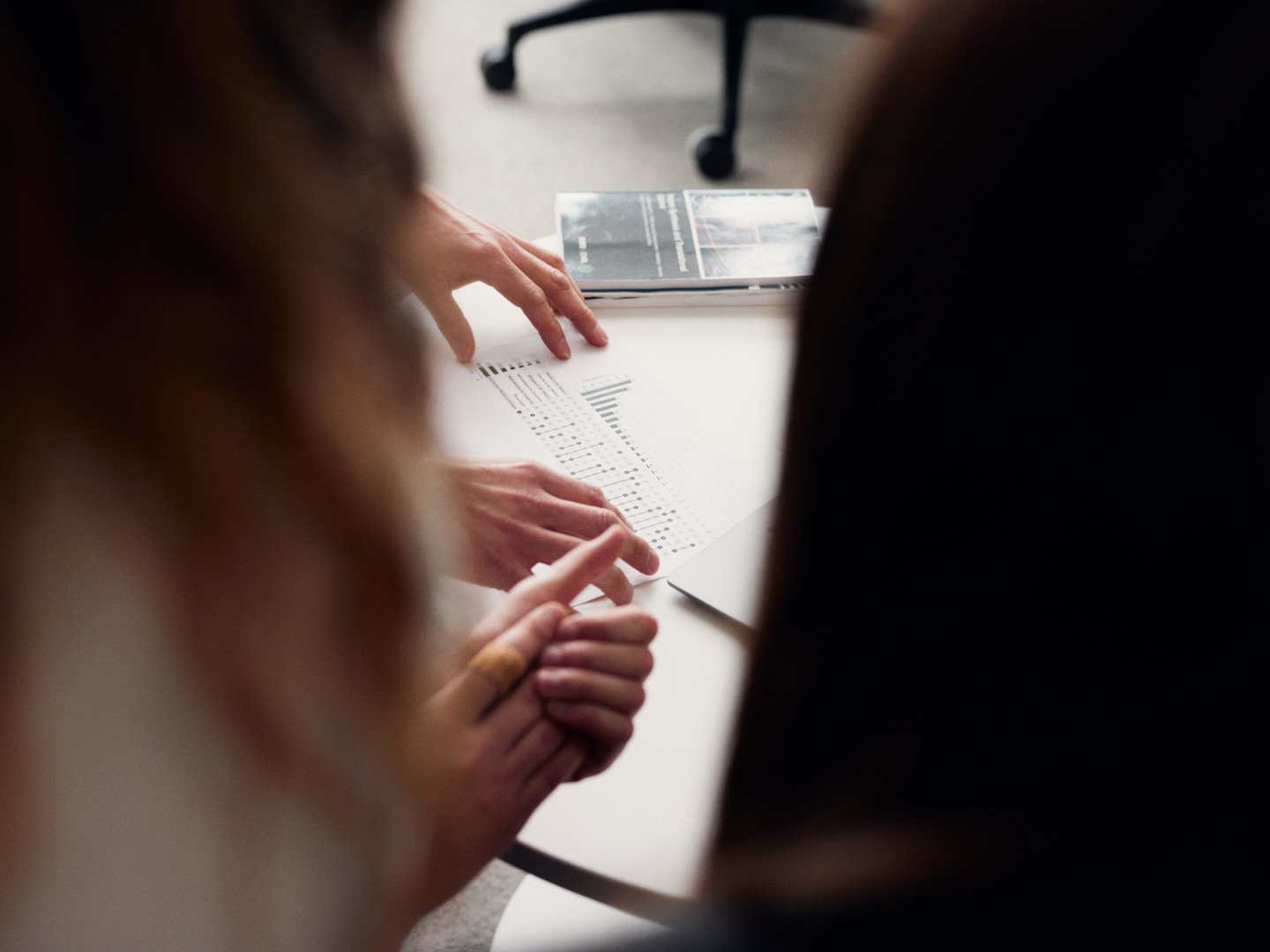 Drei Menschen schauen auf ein Blatt Papier