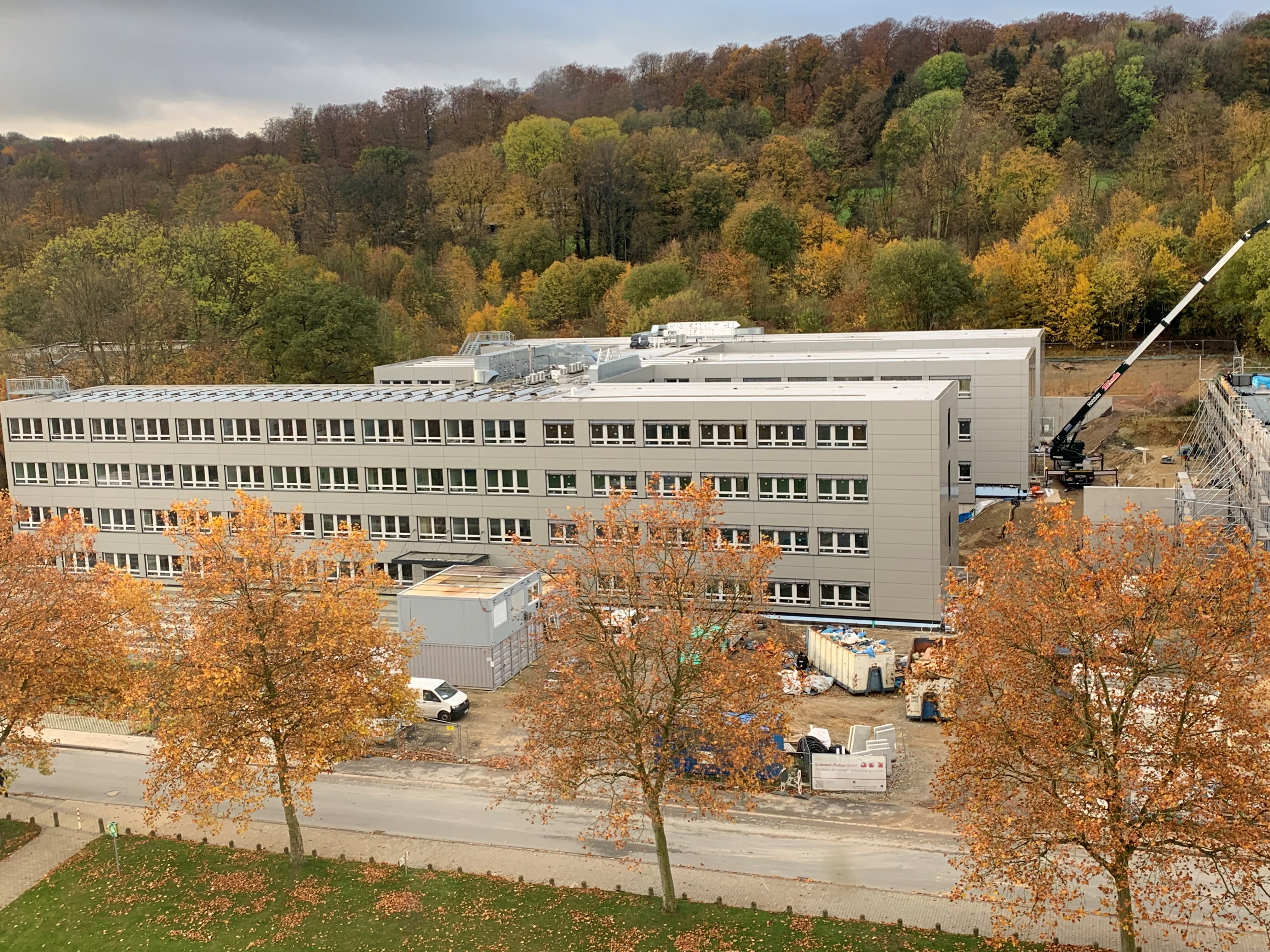 Die Gebäudeerweiterung Z.2 ist kurz vor der Fertigstellung. Blick auf das Gebäude mit Bäumen davor