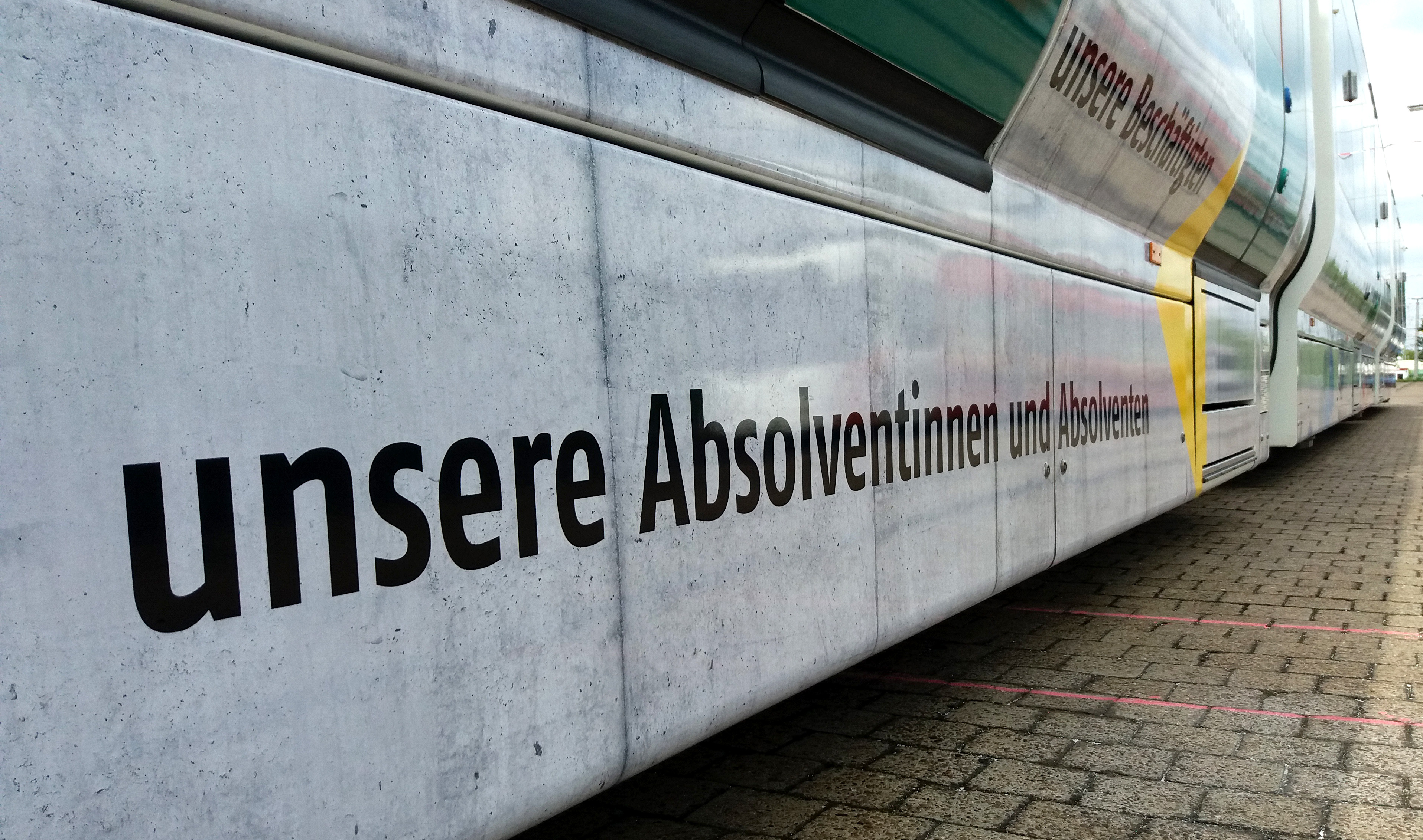 Auf der Bahn steht auch, dass die Universität ihre Absolventinnen und Absolventen feiert.