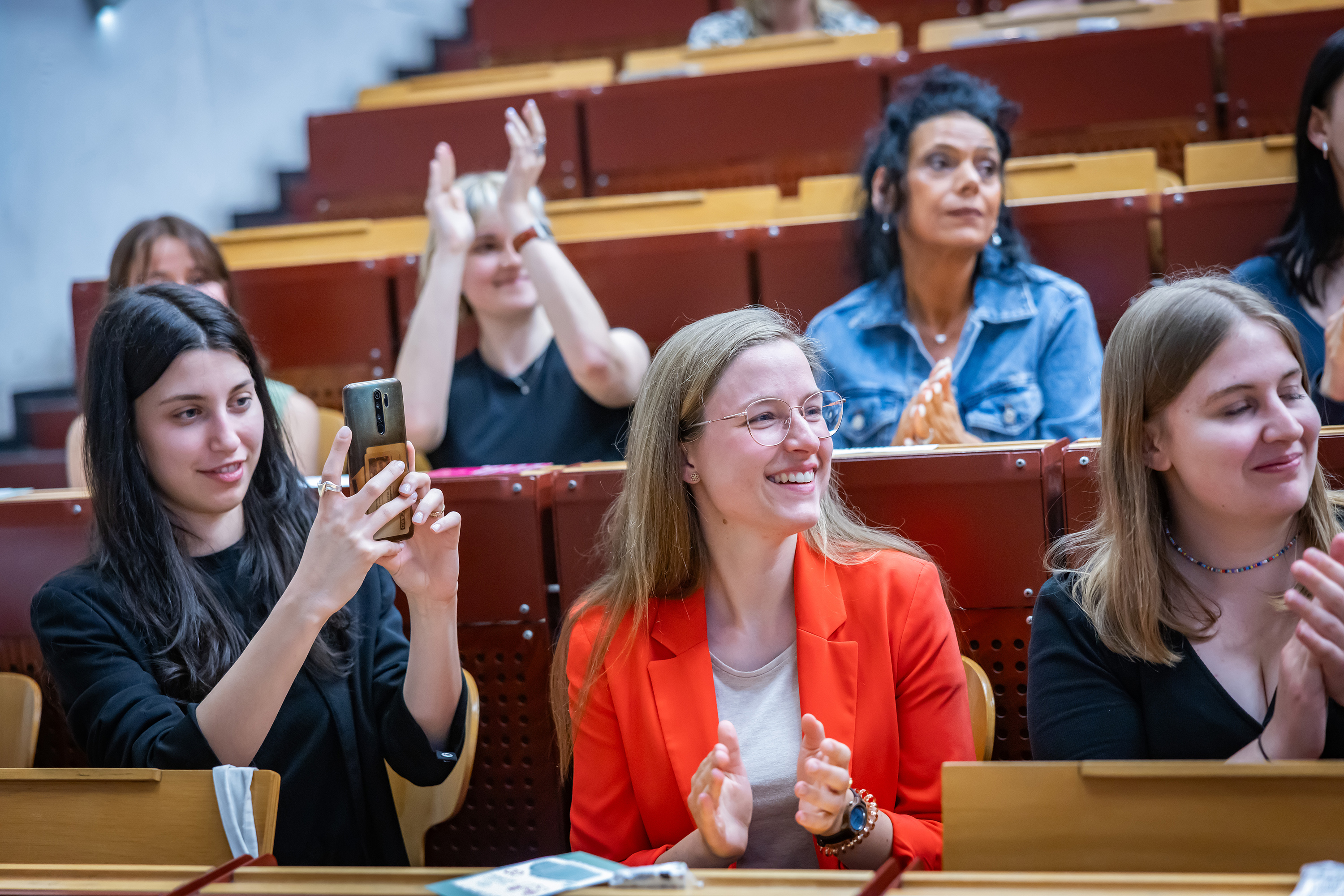 Applaudierende Menschen im Hörsaal