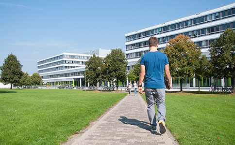 Eine Person geht auf einem der Wege, die das UHG mit dem Gebäude X verbinden