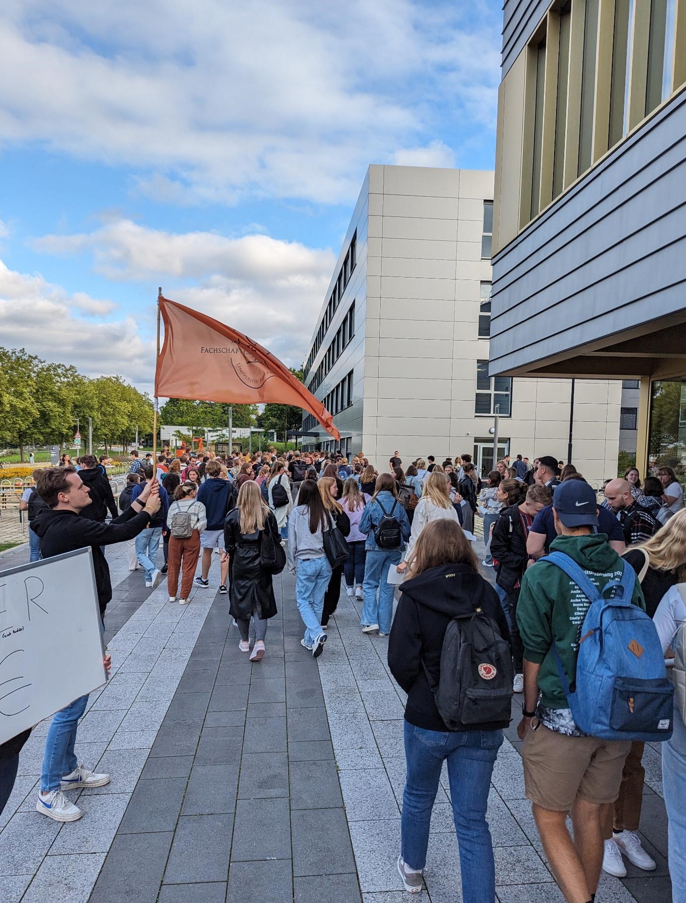 Fünf Fachschaftler*innen vor Erstsemesterstudierenden in einem Hörsaal.