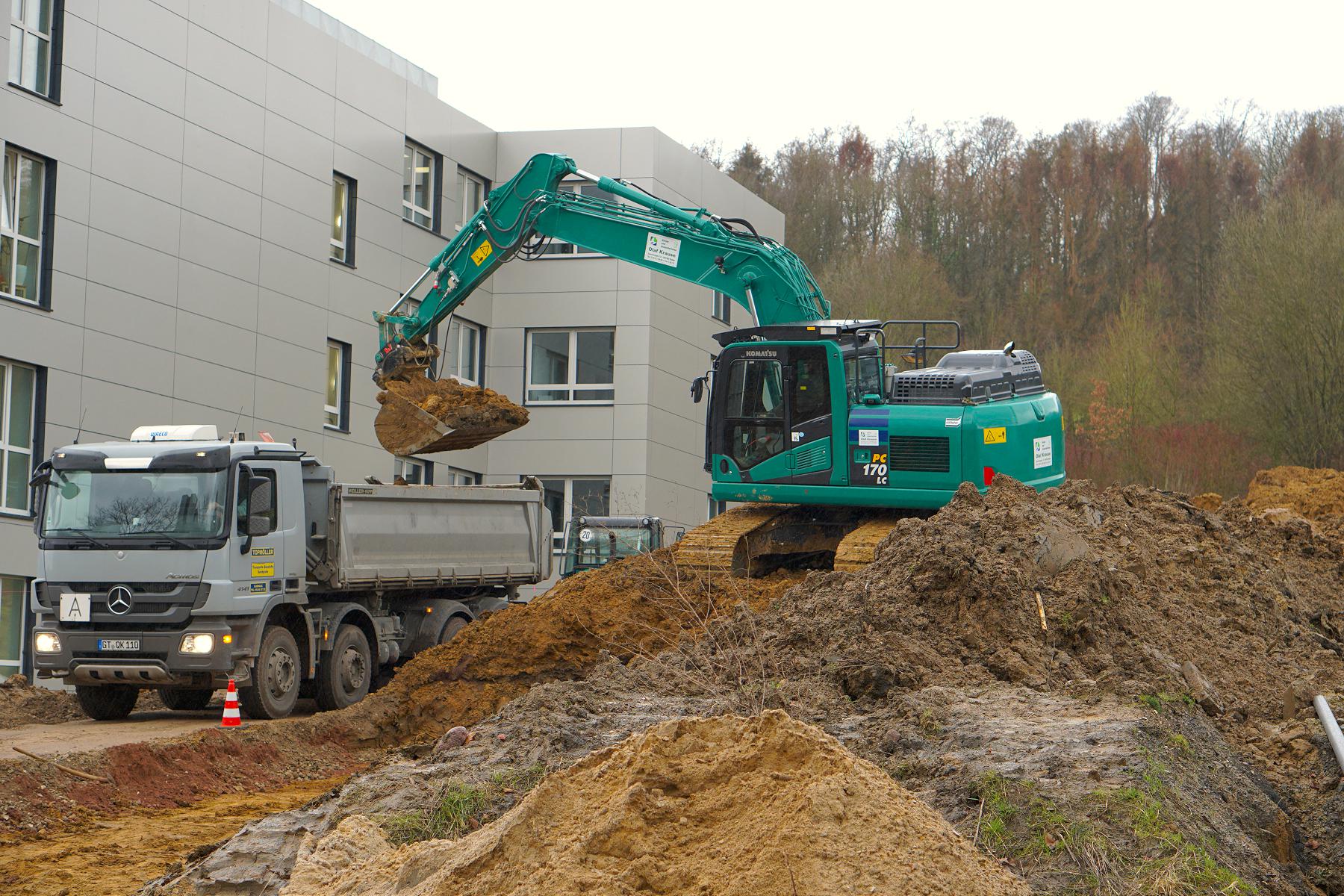 EIn Bagger auf einem Erdhügel - erste Bauarbeiten