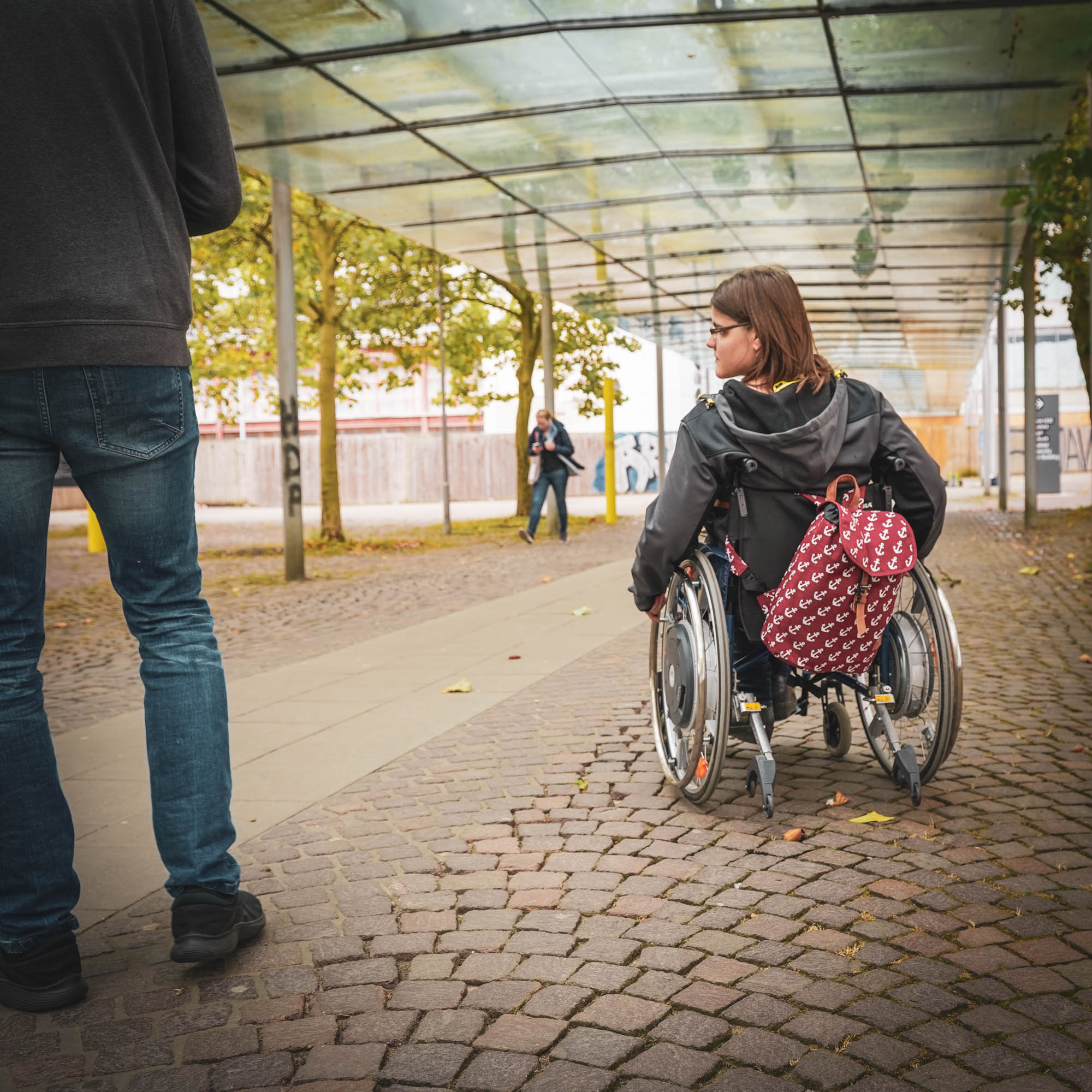 Rollstuhlfahrern vor dem Uni Eingang